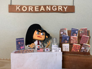 Koreangry sitting down at her zine table